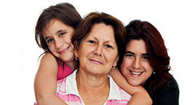 Three generations of female family members who are smiling.