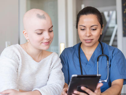 A woman with cancer is meeting with her female doctor.