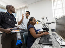 Dr. Satish Gopal in discussions with two office staff during his previous job in Malawi in Sub-Saharan Africa.