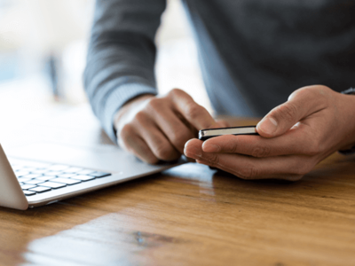 A person types on a mobile phone
